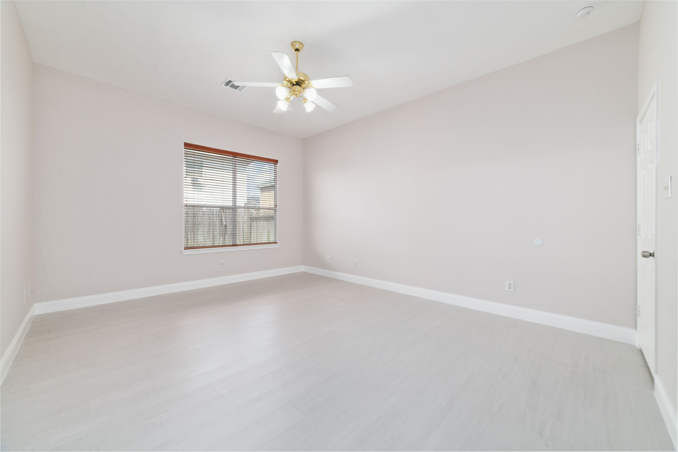 8330 Malin Court Houston, TX 77083 - Photo 13 of 21 This room features light-colored flooring and walls, creating a bright and airy atmosphere. It has a ceiling fan with lights and a window with blinds, allowing for natural light and ventilation.