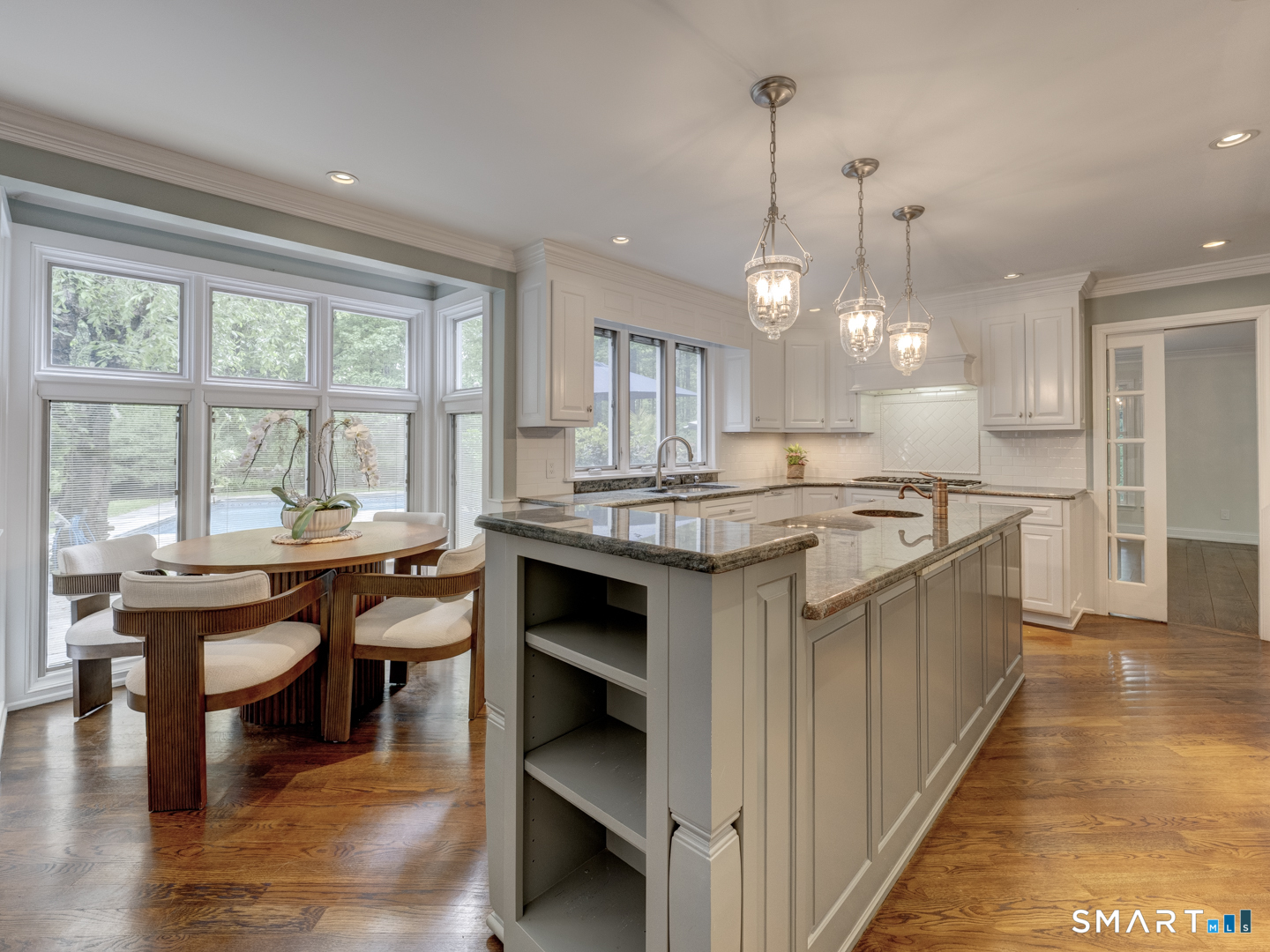 78 Windtree Street Torrington, CT 06790 - Photo 19 of 40 a kitchen with kitchen island granite countertop a stove a sink a dining table and chairs with wooden floor