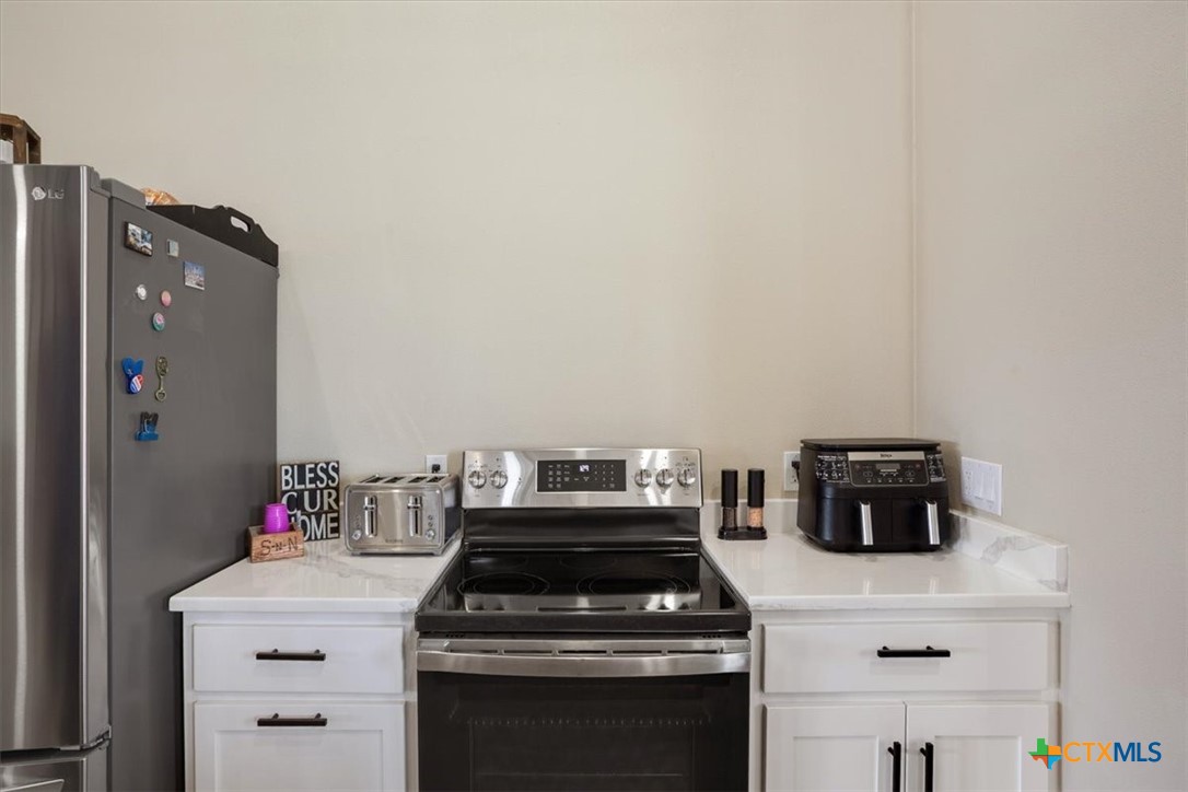 1490 Dos Hermanas Road Salado, TX 76571 - Photo 16 of 43 a kitchen with a stove and cabinets