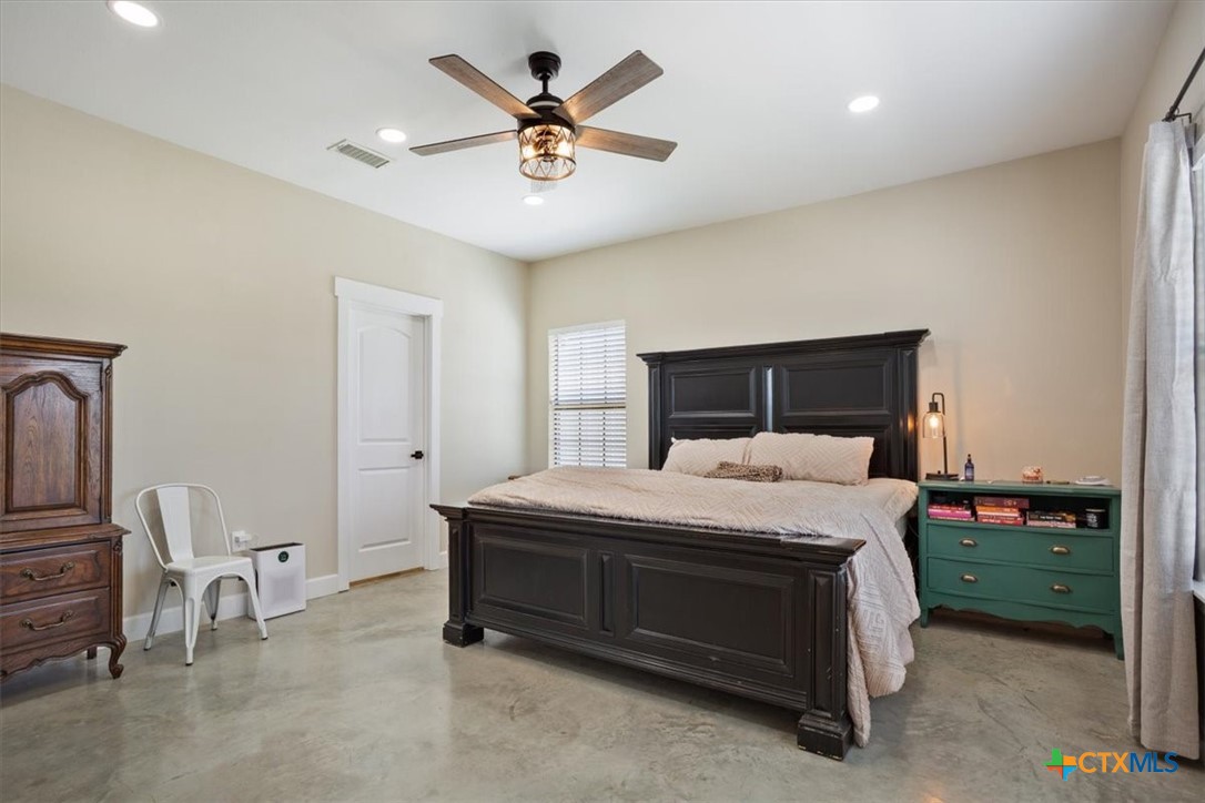 1490 Dos Hermanas Road Salado, TX 76571 - Photo 18 of 43 a bedroom with a bed and a chandelier