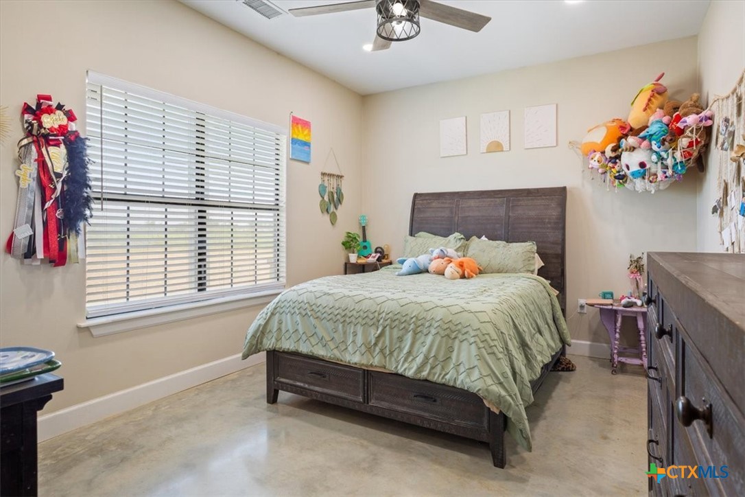 1490 Dos Hermanas Road Salado, TX 76571 - Photo 22 of 43 a spacious bedroom with a bed and a chandelier