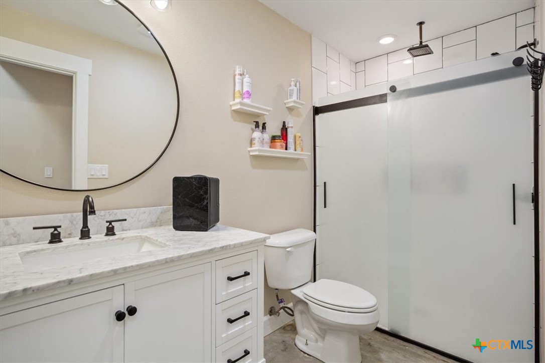 1490 Dos Hermanas Road Salado, TX 76571 - Photo 23 of 43 a bathroom with a granite countertop sink toilet and a mirror