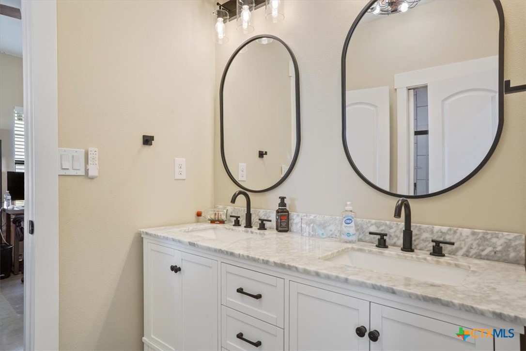 1490 Dos Hermanas Road Salado, TX 76571 - Photo 25 of 43 a bathroom with a double vanity sink and a mirror