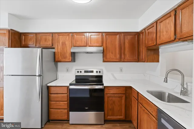 a kitchen with granite countertop a refrigerator and a sink