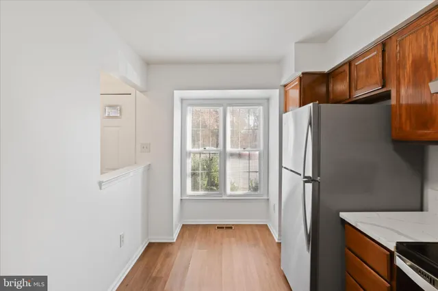 a view of a kitchen with wooden floor and electronic appliances