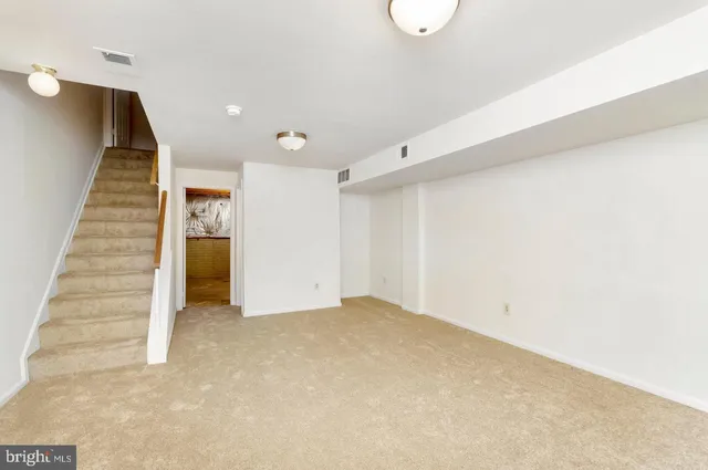 a view of an empty room with stairs and ventilation