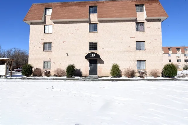front view of a brick house with a yard