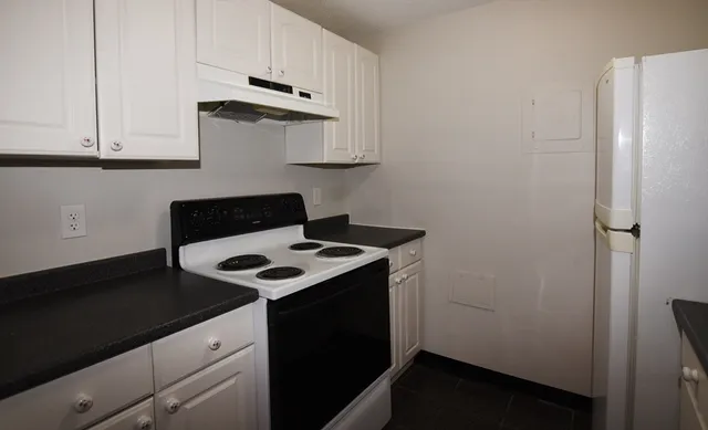 a stove top oven sitting inside of a kitchen