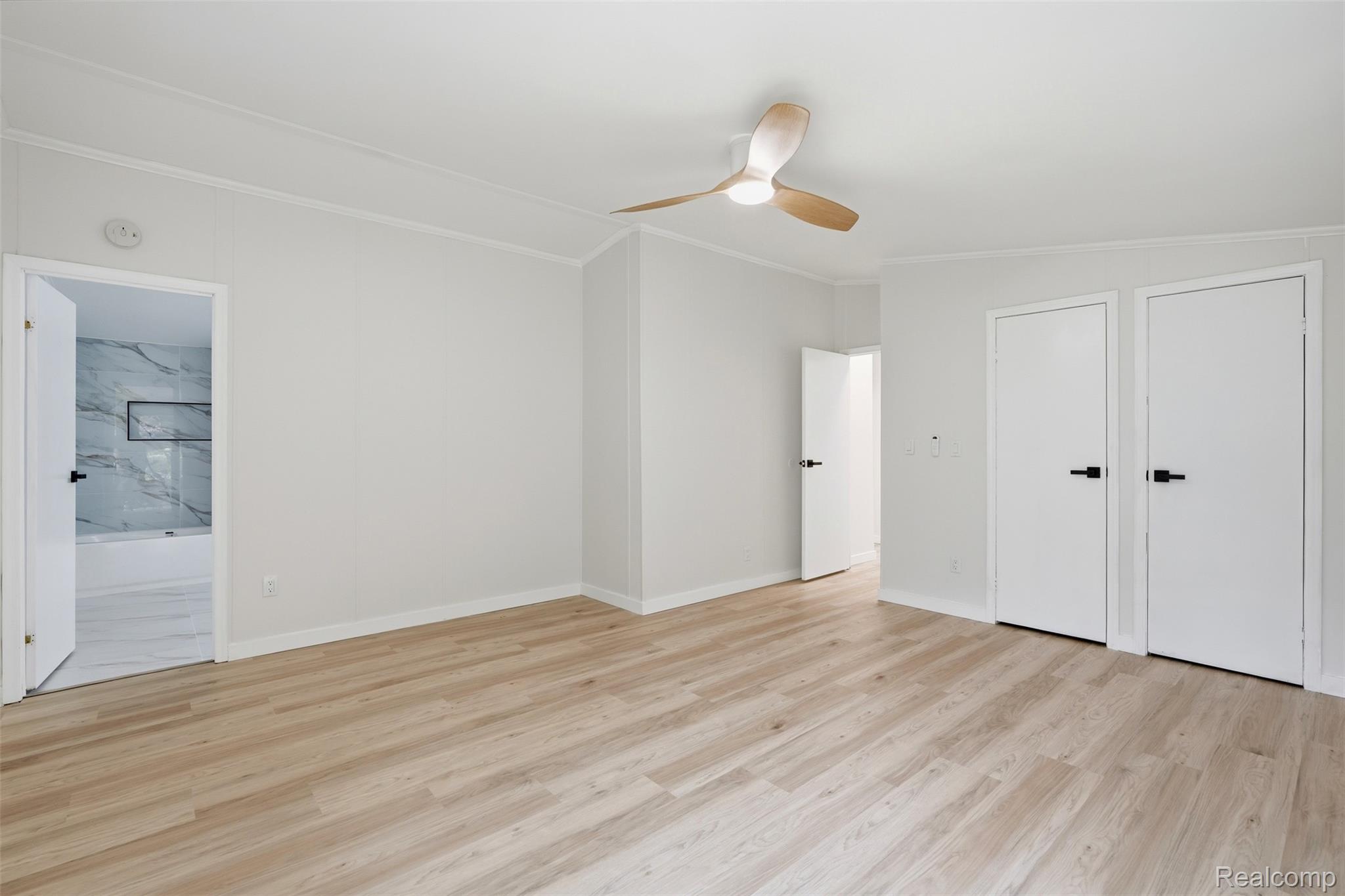 4420 Dublin Road Burton, MI 48529 - Photo 16 of 56 Spacious room featuring light wood-finish flooring, white walls with crown molding, and a contemporary ceiling fan