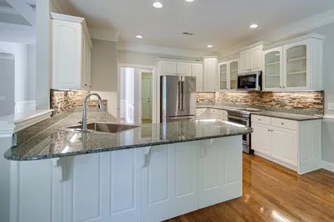 a kitchen with stainless steel appliances granite countertop a sink and stove