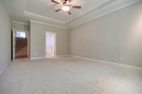 a view of an empty room with a chandelier fan