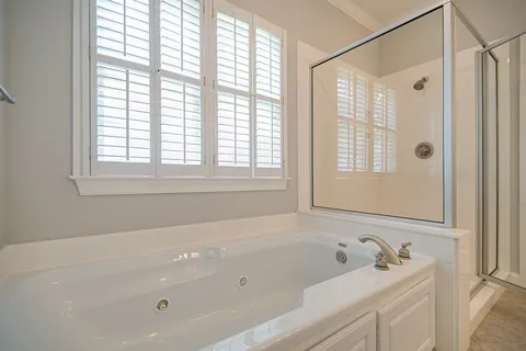 a bathroom with a tub a sink and a window
