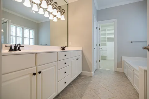 a bathroom with a double vanity sink a mirror and a bathtub