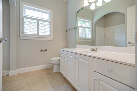 a bathroom with a toilet sink and mirror