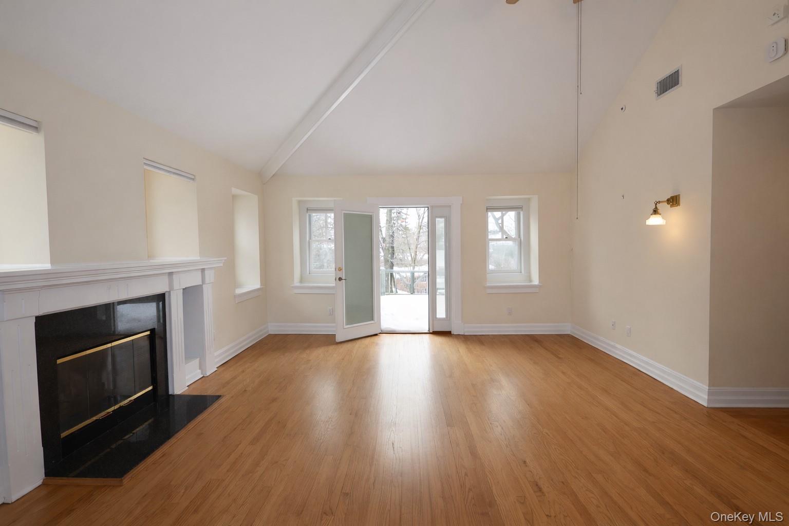 16 Clinton Avenue Dobbs Ferry, NY 10522 - Photo 15 of 26 an empty room with wooden floor fireplace and windows