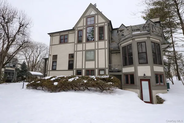 a front view of a building with cars parked