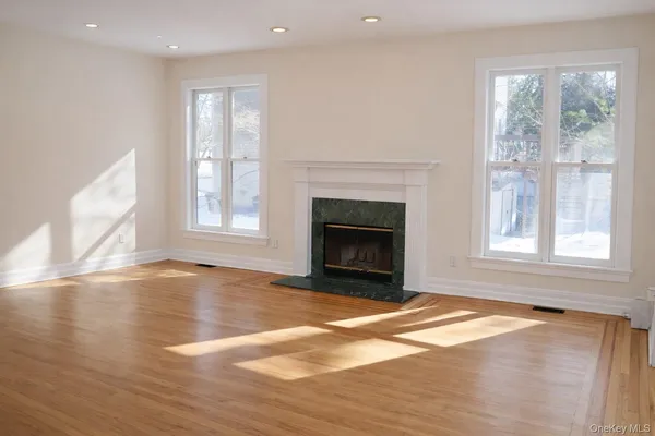 a view of empty room with wooden floor and fireplace