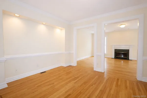 a view of empty room with wooden floor and fireplace