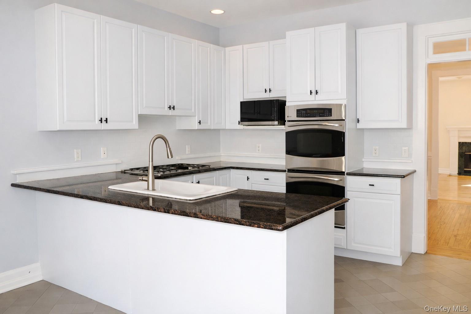 16 Clinton Avenue Dobbs Ferry, NY 10522 - Photo 6 of 26 a kitchen with granite countertop white cabinets and a sink