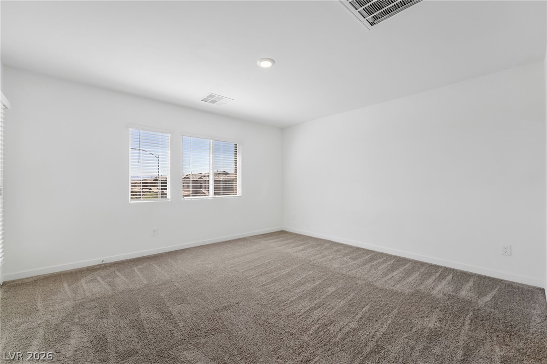 894 Cadence View Way Henderson, NV 89011 - Photo 14 of 23 An airy bedroom with fresh carpeting and ample daylight pouring through two large windows.