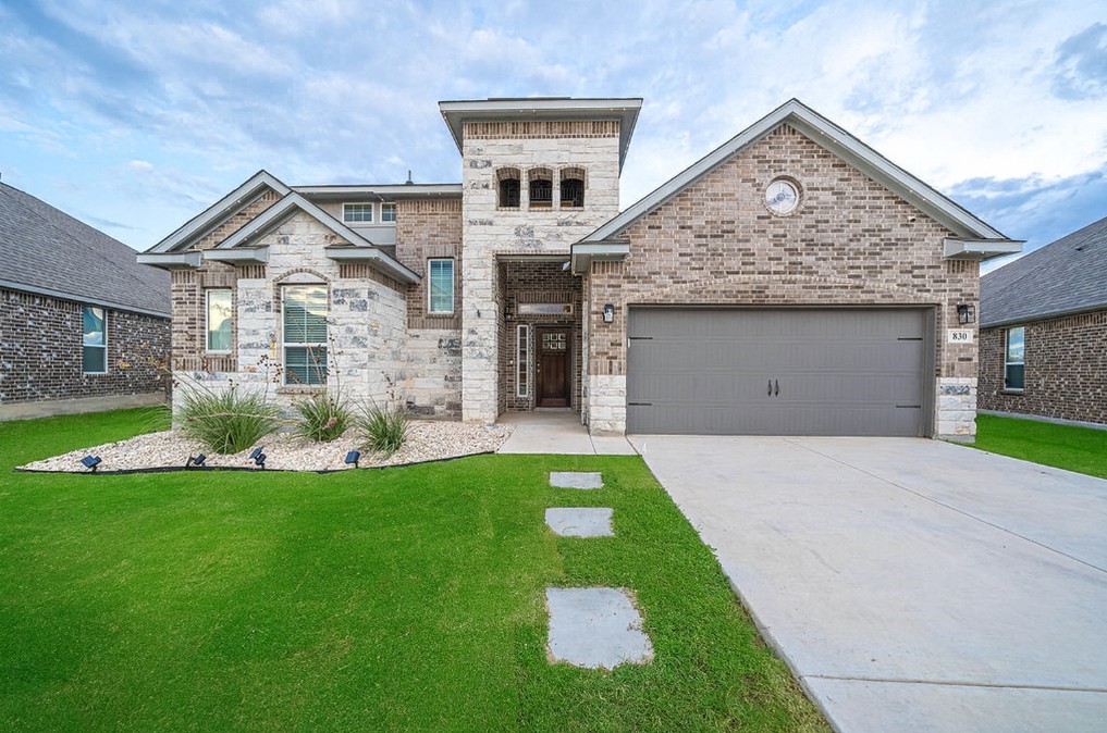 a front view of a house with a yard and garage