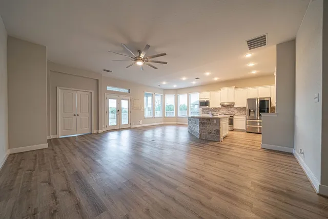 a view of a livingroom with wooden floor and a ceiling fan