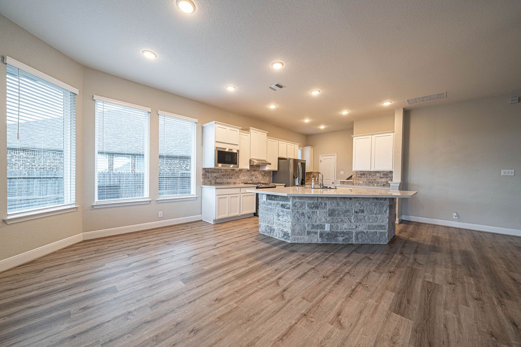 830 Rench New Braunfels, TX 78130 - Photo 8 of 50 a living room with stainless steel appliances kitchen island wooden floors wooden cabinets and entryway