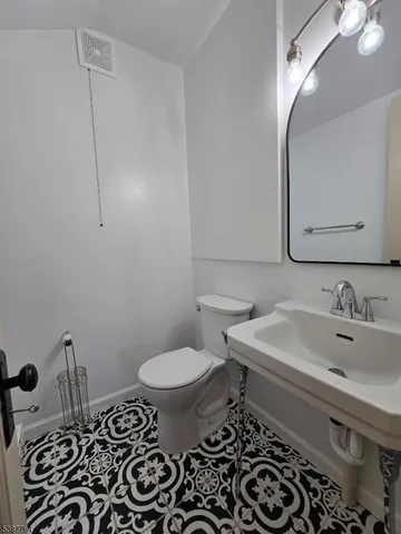 a bathroom with a sink toilet and mirror