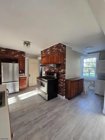 a kitchen with stainless steel appliances kitchen island wooden cabinets and granite counter tops