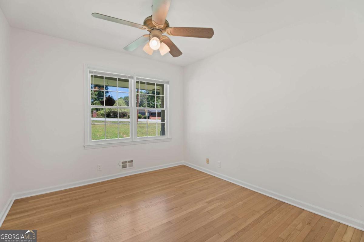 865 Old Tucker Road Stone Mountain, GA 30087 - Photo 24 of 57 an empty room with a window and a fan