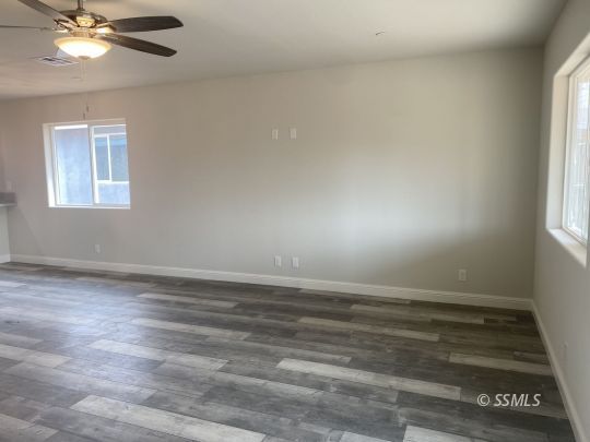 1405 Porter Street Ridgecrest, CA 93555 - Photo 8 of 23 an empty room with wooden floor and windows
