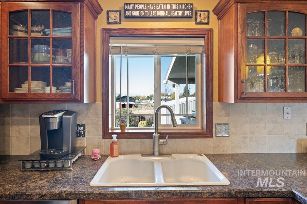 3828 15th Street Lewiston, ID 83501 - Photo 11 of 34 Kitchen with glass insert cabinets, backsplash, and brown cabinetry