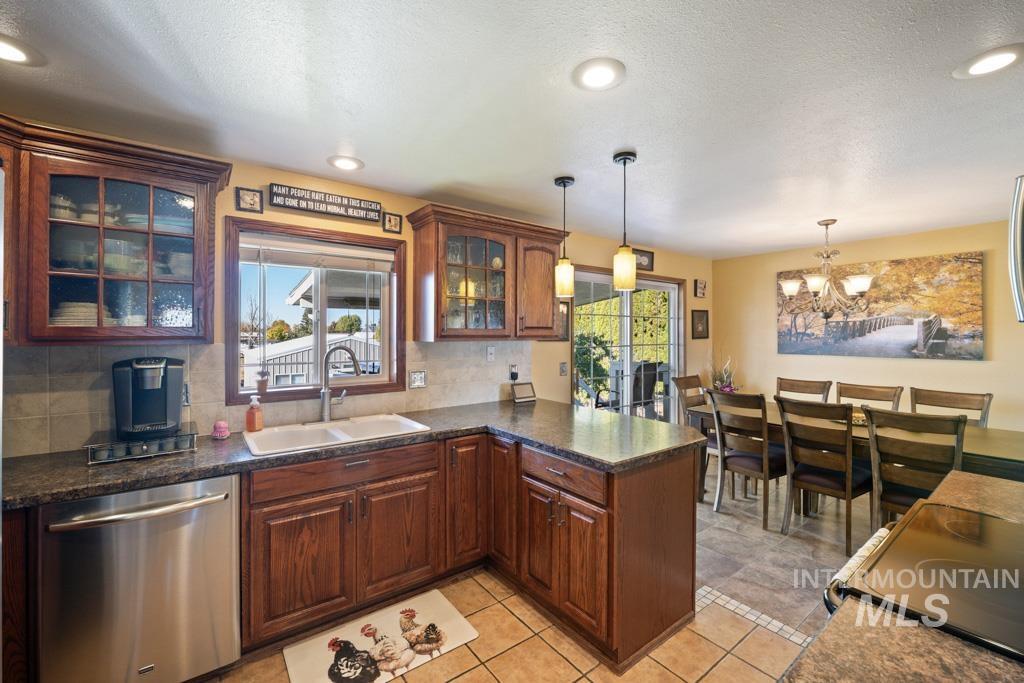 3828 15th Street Lewiston, ID 83501 - Photo 10 of 34 Kitchen with stainless steel dishwasher, glass insert cabinets, electric stove, a chandelier, and hanging light fixtures