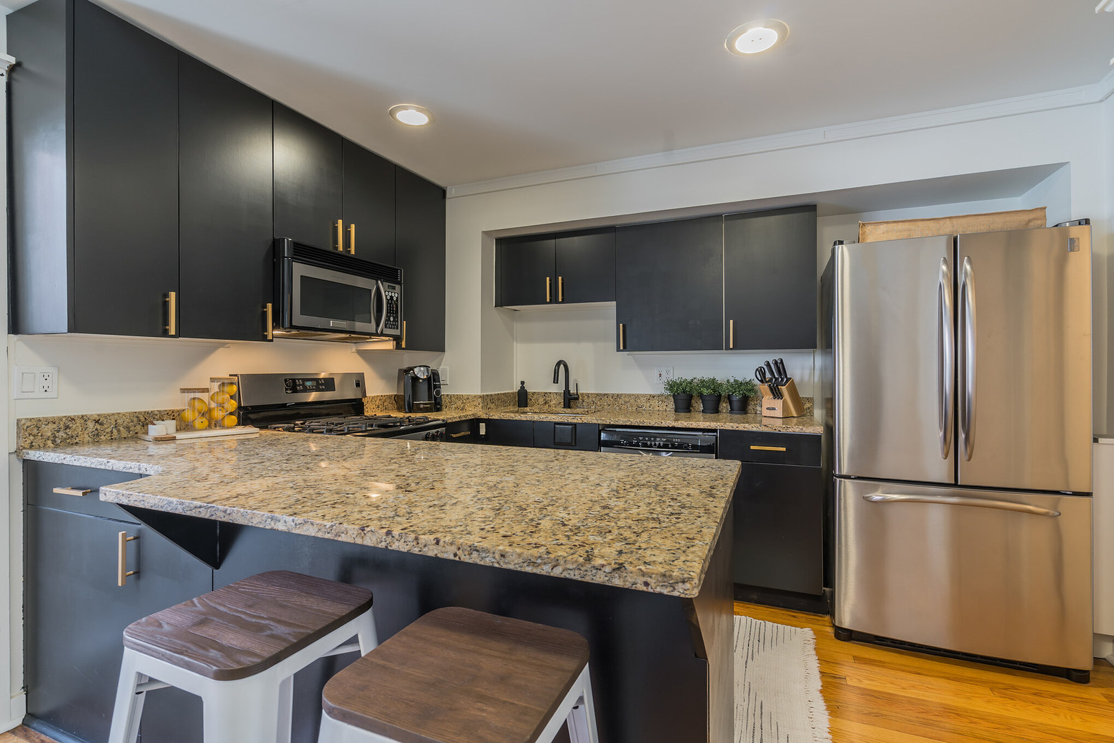 2729 North Racine Avenue, Unit N Chicago, IL 60614 - Photo 7 of 21 a kitchen with granite countertop a refrigerator a stove a sink dishwasher and wooden cabinets with wooden floor