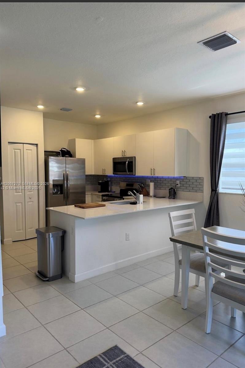 16220 Southwest 288th Terrace Homestead, FL 33033 - Photo 4 of 6 a kitchen with stainless steel appliances granite countertop a refrigerator and a stove top oven