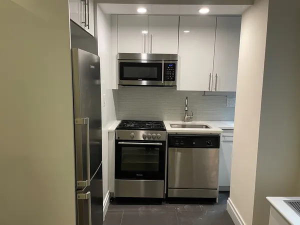 a kitchen with stainless steel appliances a stove a microwave and sink