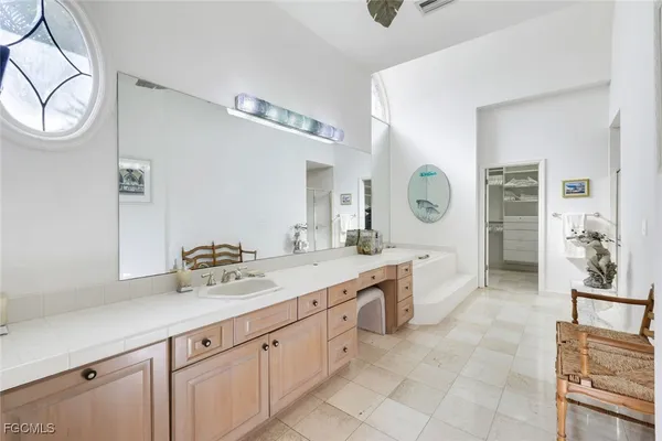 a spacious bathroom with a granite countertop sink mirror and bathtub