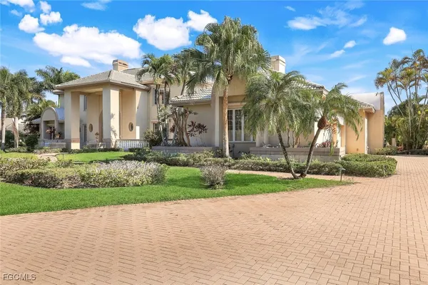 a view of a white house with a yard and plants