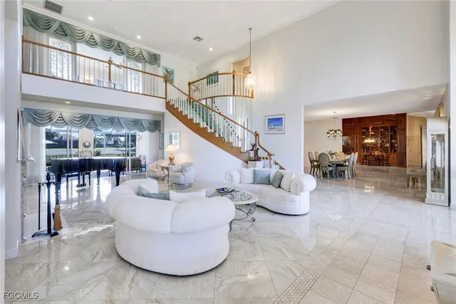 a living room with couches and a dining table with entryway