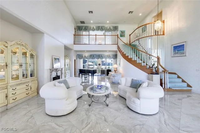 a living room with couches and kitchen view with wooden floor