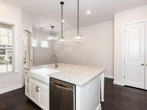 a kitchen that has a sink a microwave and a wooden floor