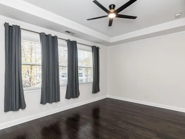 an empty room with wooden floor and windows
