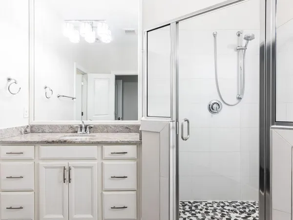 a bathroom with a granite countertop sink a shower and a mirror