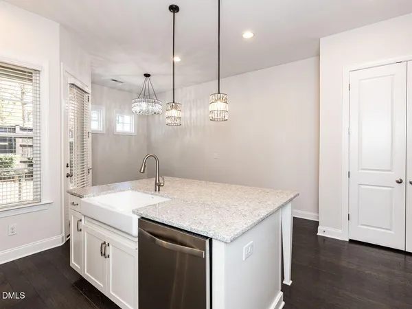a kitchen that has a sink a microwave and a wooden floor