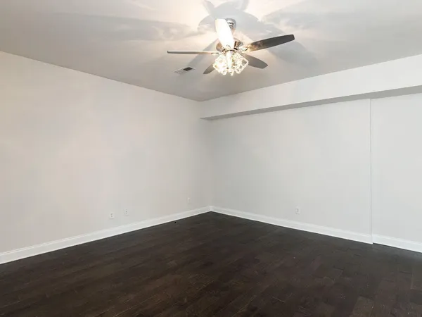 a view of a room with wooden floor and fan