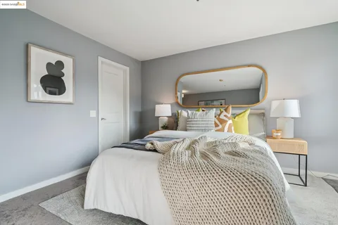 a bedroom with a bed and a painting on the wall