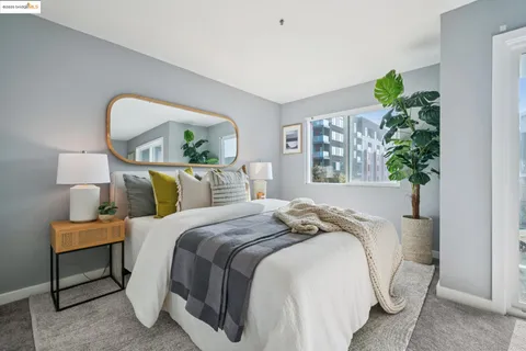 a bed sitting in a bedroom next to a window and a lamp