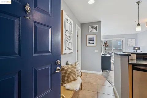 a room with stainless steel appliances kitchen island granite countertop a refrigerator and a sink