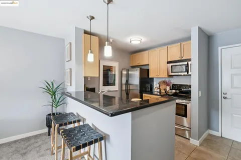 a kitchen with stainless steel appliances granite countertop a stove a refrigerator and a sink