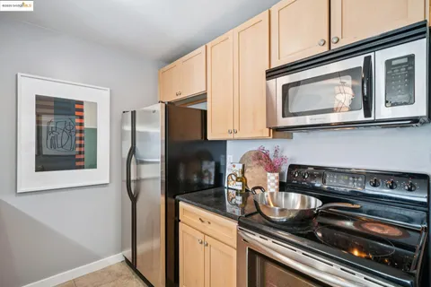 a kitchen with stainless steel appliances granite countertop a refrigerator and a stove top oven